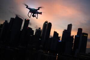 A drone at dusk in front of a city skyline