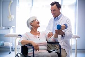 Physiotherapist assisting senior patient with hand exercise as part of an exercise prescription