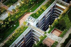 Aerial shot of a residential estate complex with green plants on the roof as a method to develop sustainable building and energy efficiency.