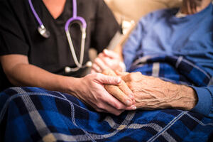 Palliative care - medical practitioner holding hands of patient
