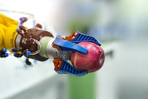 Robotic arm holding an apple in a science lab 