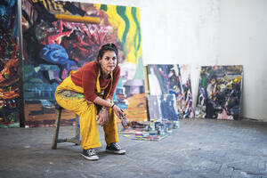 Female artist in paint covered studio