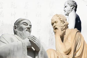 Three statues of ancient Chinese and Western philosophers against a backdrop of Chinese calligraphy.