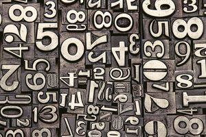 Maths Puzzles: a photograph of old metal numbers