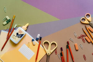 An arrangement of paper, scissors, pencils and clips