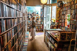 A woman in a bookshop in Edinburgh, staring at the shelves. 
